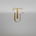 A large metallic gold decorative letter L with an arched top and a wide flat base, centered on a warm cream background with subtle decorative gold accents.